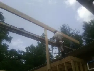 Carpenter setting a ridge beam over a new addition frame — Ice Dam Removal by Roofing Brothers in Mount Ulla