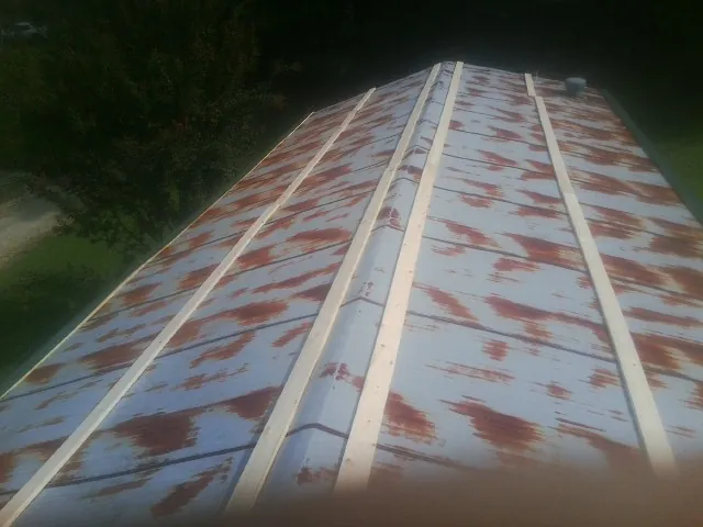 Rusted metal roof panels with new wood purlins before replacement — Storm Damage Roof Repair in Mount Ulla by Roofing Brothers