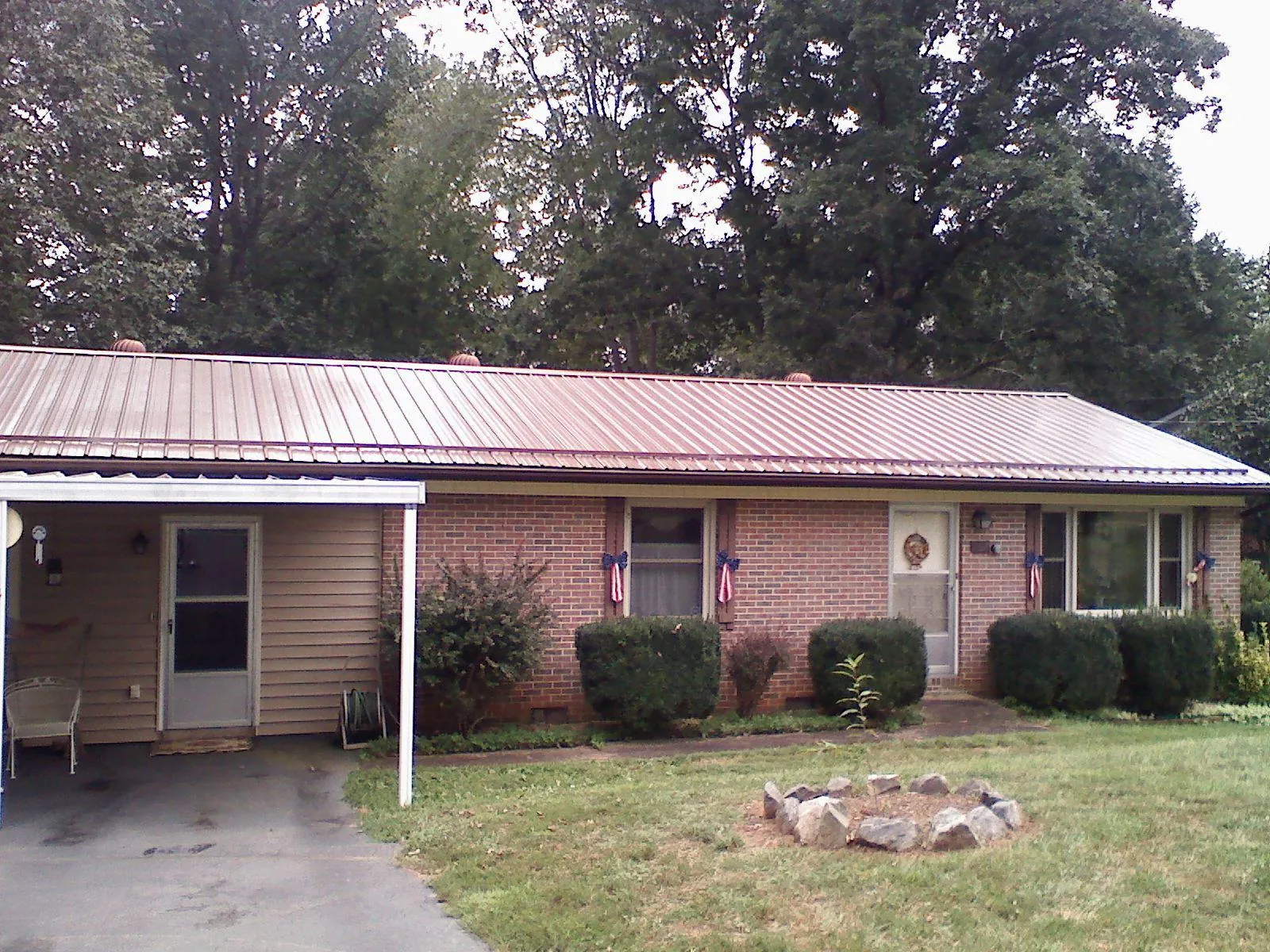 Bronze metal roof and carport on a brick ranch home — Roof Repair work by our crew in Mount Ulla